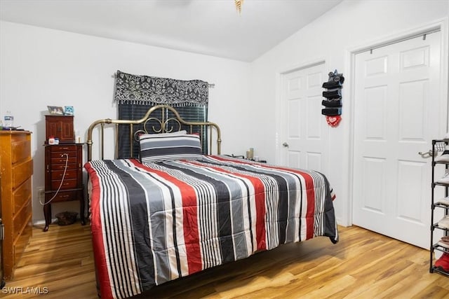 bedroom featuring hardwood / wood-style flooring and lofted ceiling