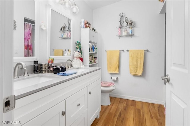 bathroom featuring hardwood / wood-style flooring, vanity, and toilet