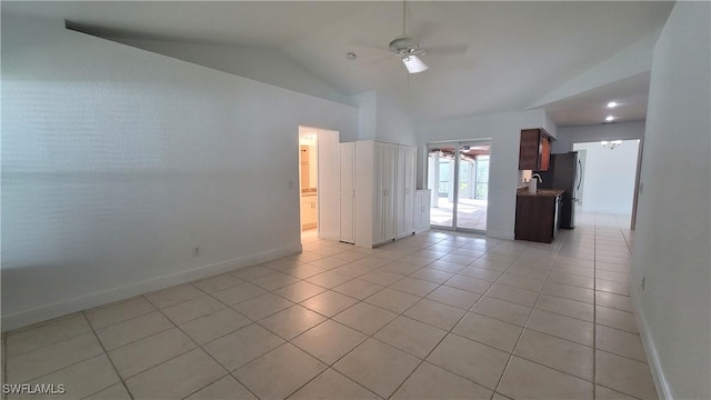 tiled empty room with ceiling fan, sink, and vaulted ceiling