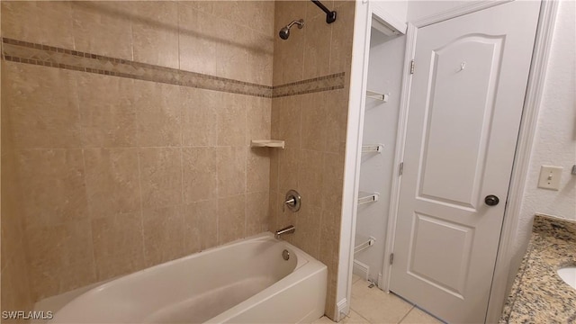 bathroom featuring tile patterned flooring, vanity, and tiled shower / bath