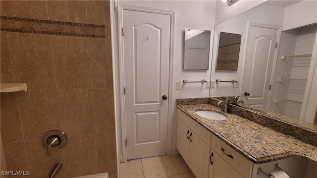 bathroom featuring tile patterned flooring, vanity, and tiled shower / bath combo