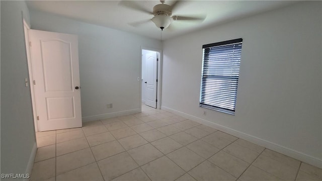 empty room featuring ceiling fan and light tile patterned floors