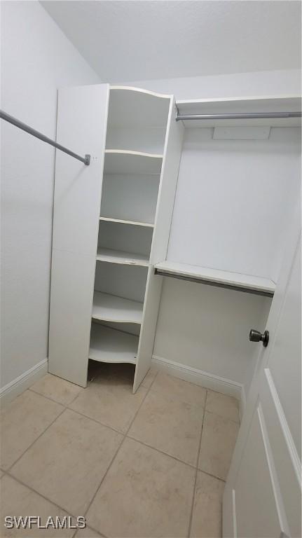 spacious closet with light tile patterned floors