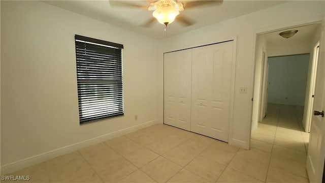 unfurnished bedroom featuring ceiling fan, a closet, and light tile patterned floors