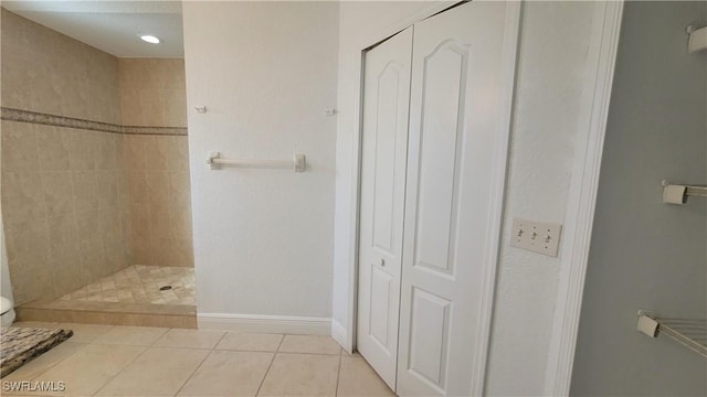 bathroom with tile patterned flooring and tiled shower