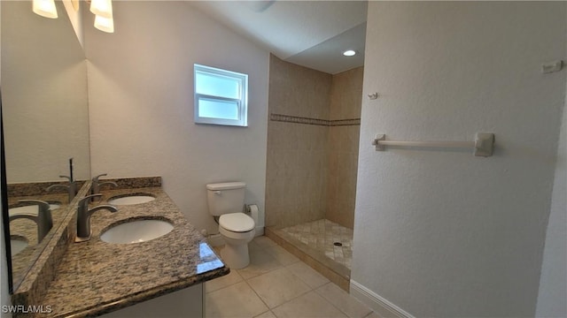 bathroom with tile patterned floors, vanity, tiled shower, toilet, and lofted ceiling