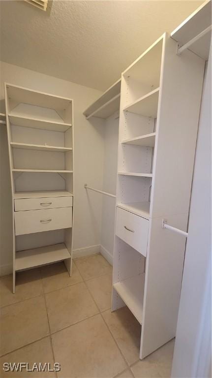 spacious closet featuring light tile patterned floors