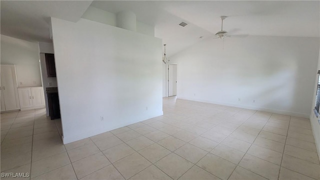 tiled empty room featuring ceiling fan and vaulted ceiling