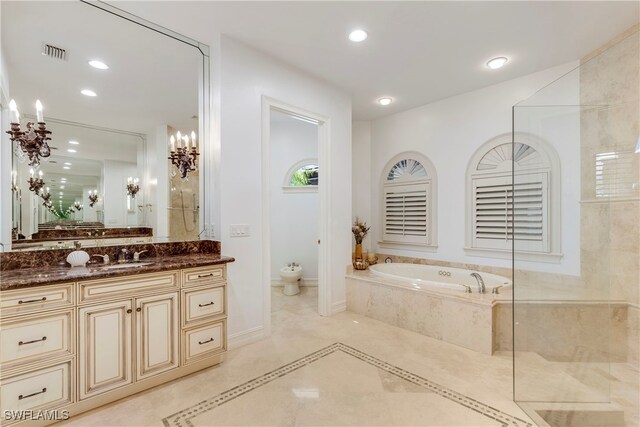 bathroom featuring vanity, tiled bath, and a bidet