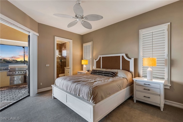 bedroom featuring dark carpet, ensuite bath, and ceiling fan