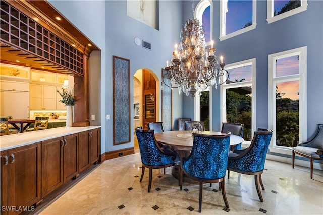 dining space with a high ceiling and an inviting chandelier