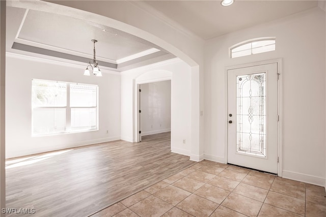 entrance foyer featuring a chandelier, crown molding, plenty of natural light, and light hardwood / wood-style floors