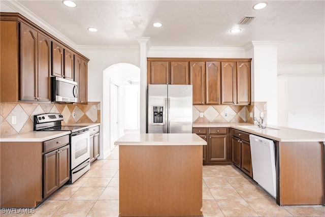 kitchen with stainless steel appliances, backsplash, kitchen peninsula, crown molding, and light tile patterned flooring