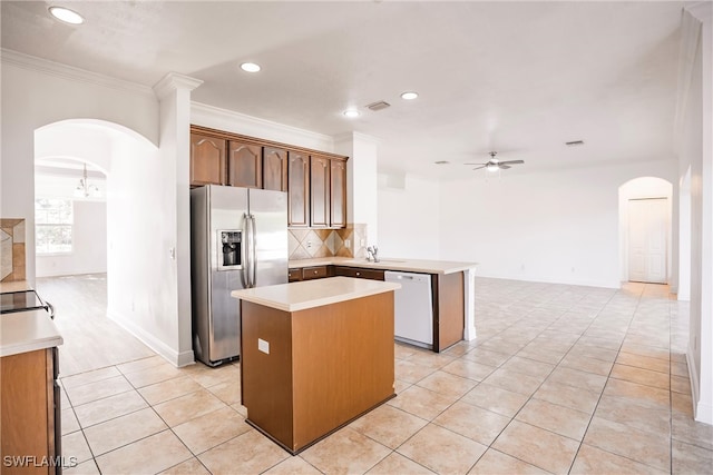 kitchen featuring ceiling fan, stainless steel refrigerator with ice dispenser, crown molding, white dishwasher, and a kitchen island