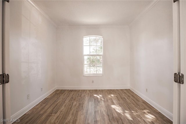 empty room with crown molding and dark wood-type flooring