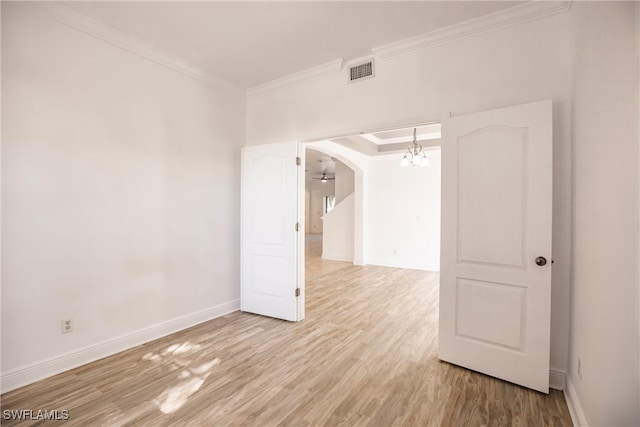 spare room with hardwood / wood-style flooring, a notable chandelier, and ornamental molding