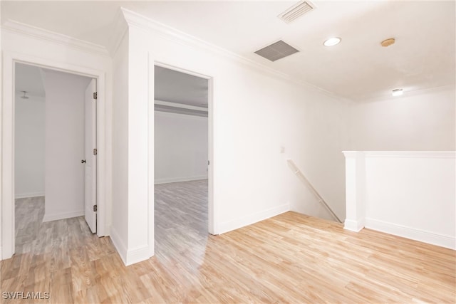 spare room featuring light hardwood / wood-style floors and crown molding