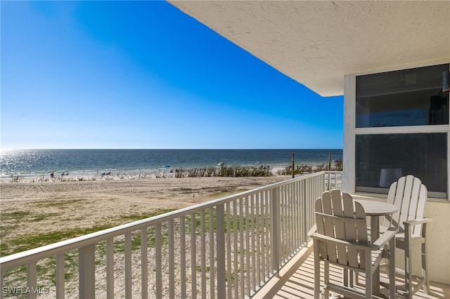 balcony with a water view and a beach view