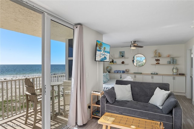 living room featuring a beach view, expansive windows, and ceiling fan