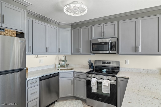 kitchen with light stone countertops, appliances with stainless steel finishes, gray cabinetry, and sink