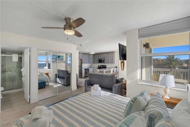 living room featuring light hardwood / wood-style floors, ceiling fan, and a healthy amount of sunlight