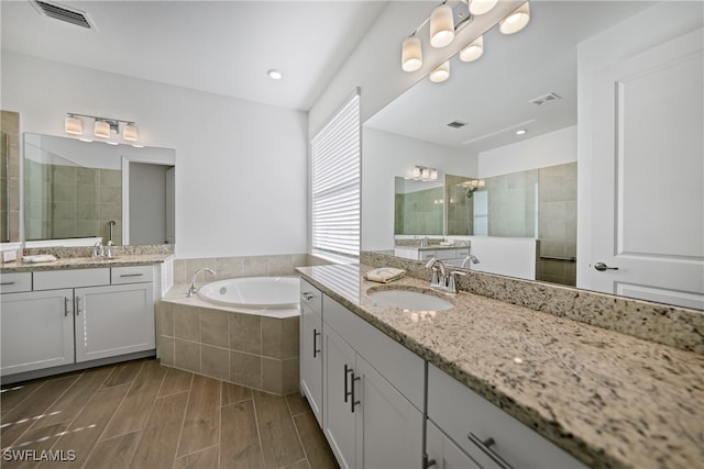 bathroom featuring shower with separate bathtub and vanity