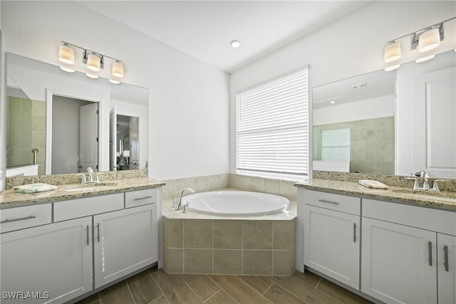 bathroom with separate shower and tub, hardwood / wood-style floors, and vanity