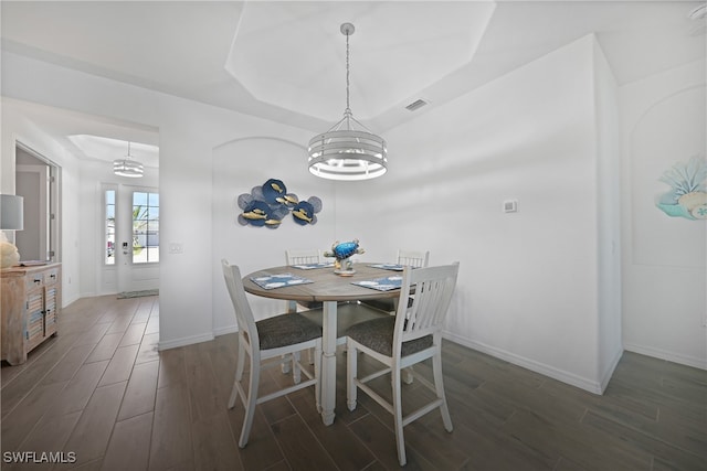 dining room with dark hardwood / wood-style flooring and a chandelier