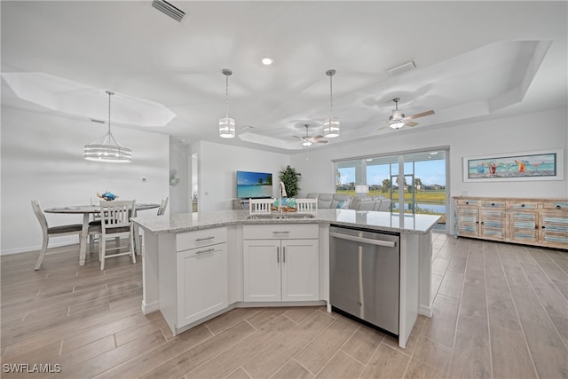 kitchen featuring a kitchen island with sink, dishwasher, white cabinets, and decorative light fixtures