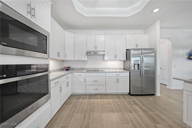 kitchen with light stone counters, white cabinets, light hardwood / wood-style floors, and appliances with stainless steel finishes