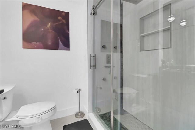 bathroom with an enclosed shower and toilet