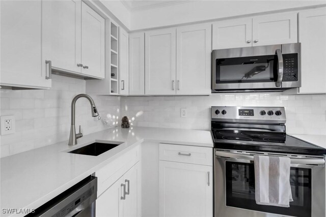 kitchen featuring appliances with stainless steel finishes, tasteful backsplash, and white cabinetry