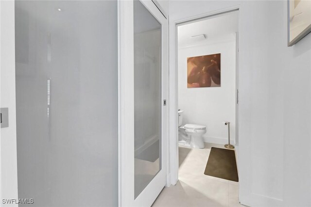 bathroom with a shower, tile patterned flooring, and toilet