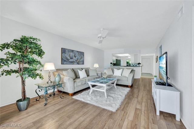 living room featuring light hardwood / wood-style flooring and ceiling fan