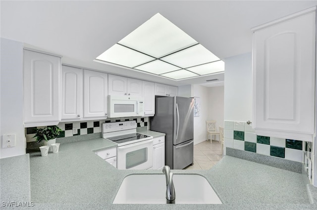 kitchen with sink, white appliances, and white cabinets