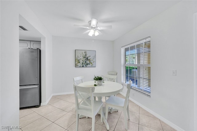 tiled dining area with ceiling fan