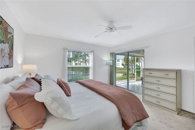 carpeted bedroom featuring multiple windows, access to exterior, and ceiling fan