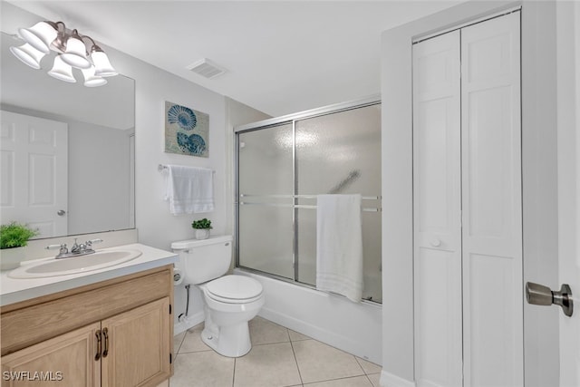 full bathroom featuring bath / shower combo with glass door, a chandelier, vanity, toilet, and tile patterned floors