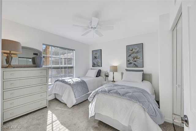 bedroom with light carpet, ceiling fan, and a closet