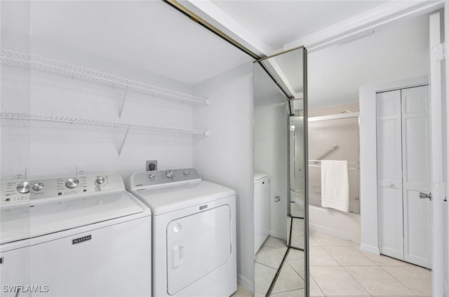 washroom with washing machine and dryer and light tile patterned flooring