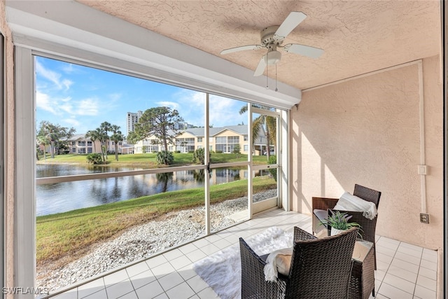 sunroom / solarium with a water view and ceiling fan