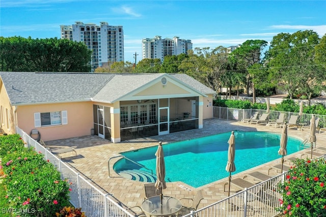 view of swimming pool with a patio and a sunroom