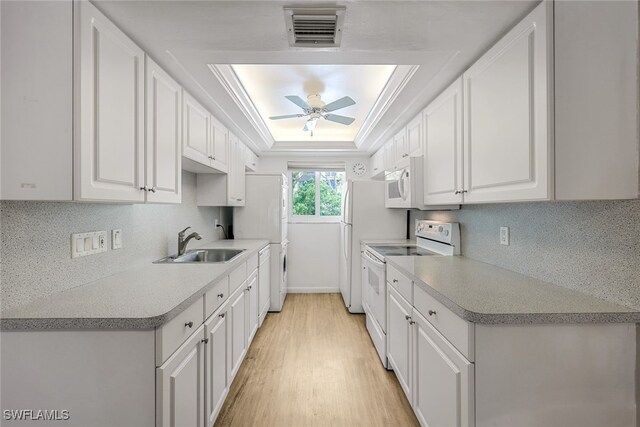 kitchen featuring white cabinetry, sink, white appliances, and a raised ceiling