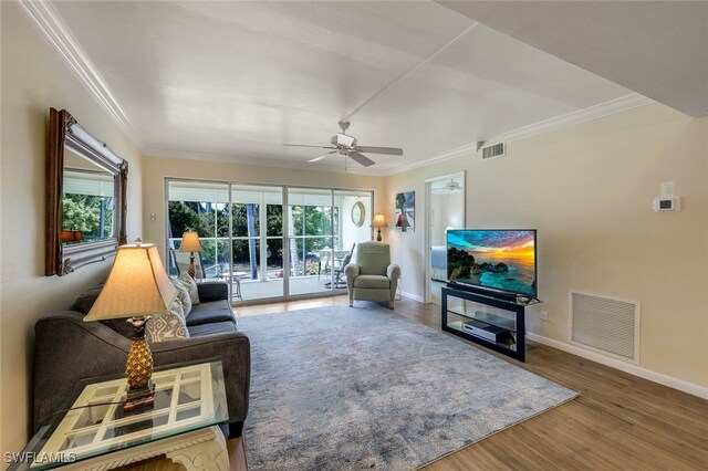 living room with ceiling fan, crown molding, and wood-type flooring