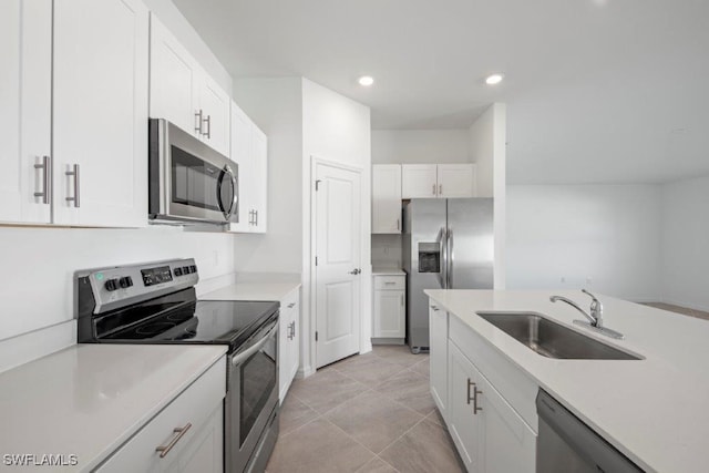 kitchen with white cabinets, light tile patterned flooring, sink, and appliances with stainless steel finishes