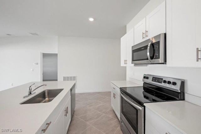 kitchen featuring white cabinets, light tile patterned floors, sink, and appliances with stainless steel finishes