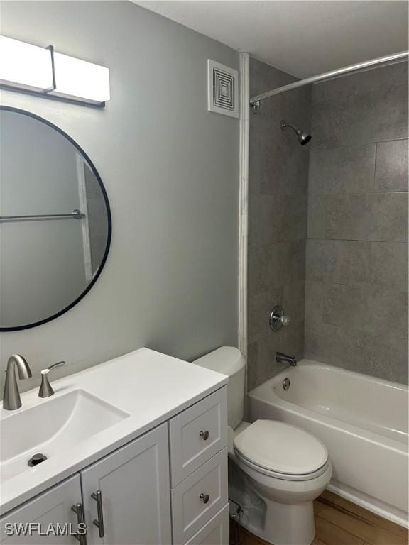 full bathroom featuring bathing tub / shower combination, visible vents, toilet, vanity, and wood finished floors