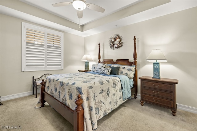 bedroom featuring light carpet, baseboards, and a ceiling fan