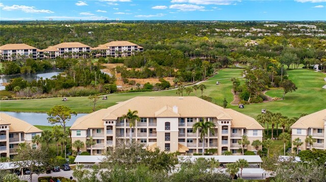 drone / aerial view featuring a water view, view of golf course, and a residential view