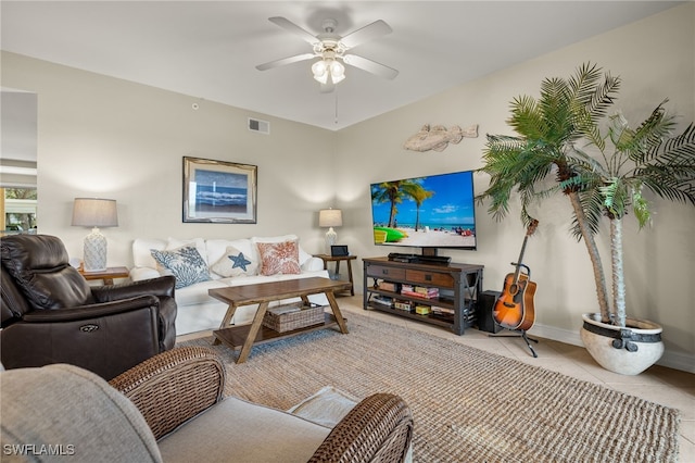 living area featuring tile patterned flooring, visible vents, ceiling fan, and baseboards